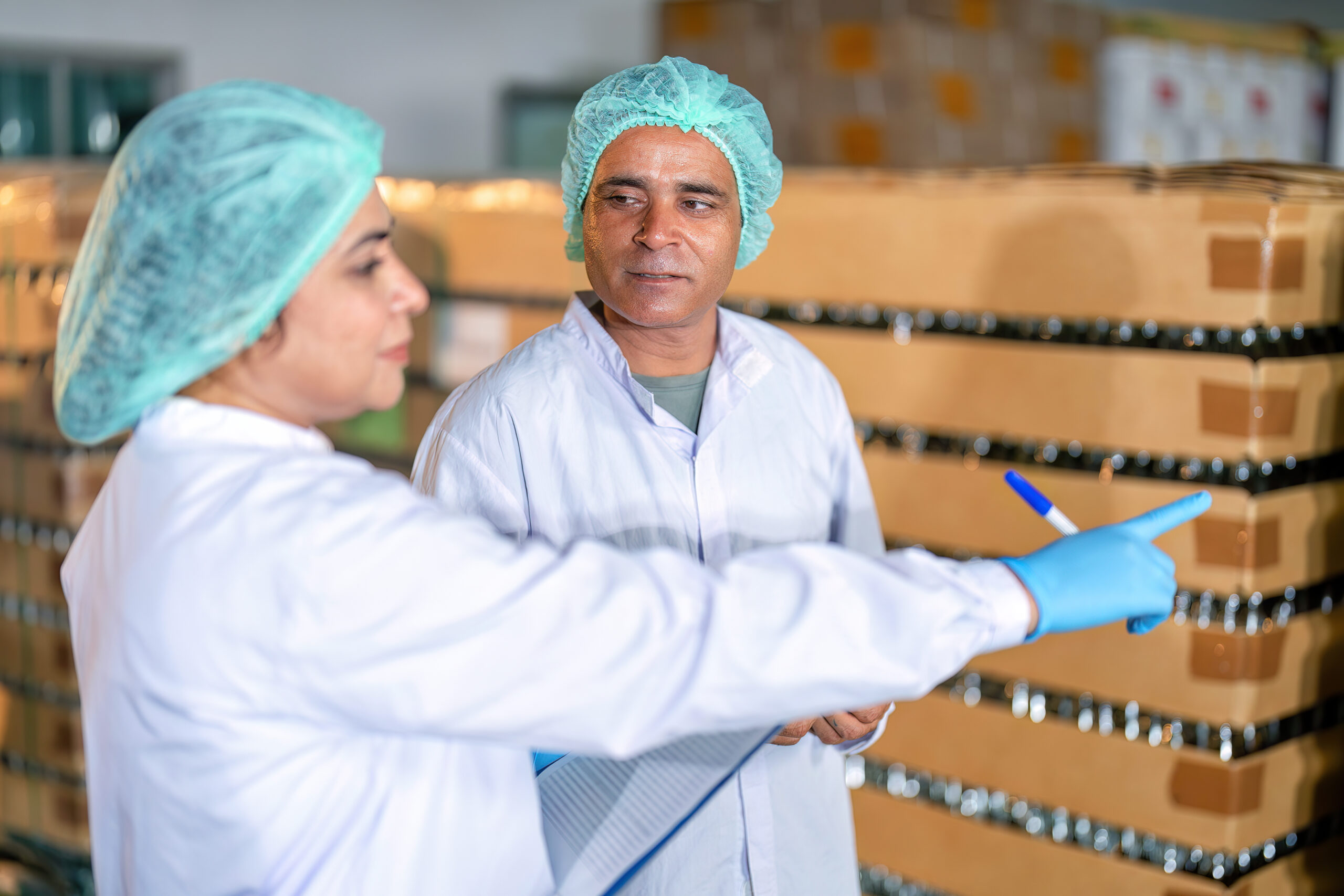 in warehouse quality control team checking drinking bottle stack on pallet before delivery